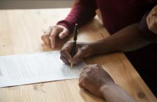 Two people signing a document