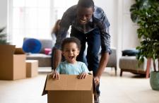 Dad pushing a happy kid in a moving box