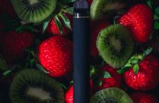 E-cigarette laying on strawberries and kiwi