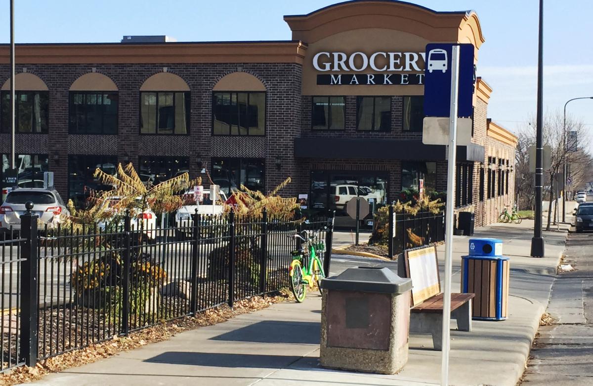 Photo of a grocery store next to a bus stop