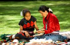 Native American woman and child reading outside