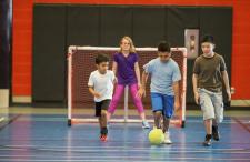 Kids playing soccer in gym class 