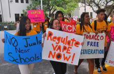 Kids holding signs in a march. The signs say No Juul Near Schools, Regulate Vape Now! and Tobacco Free Generation