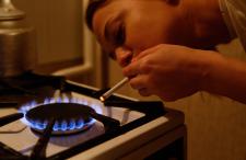 Person lighting cigarette from gas stove flame