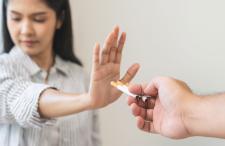 Teenager pushing away cigarette offer from another person