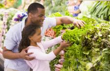 Dad and daughter buying vegetables at the grocery store