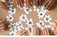 Several people putting a puzzle together